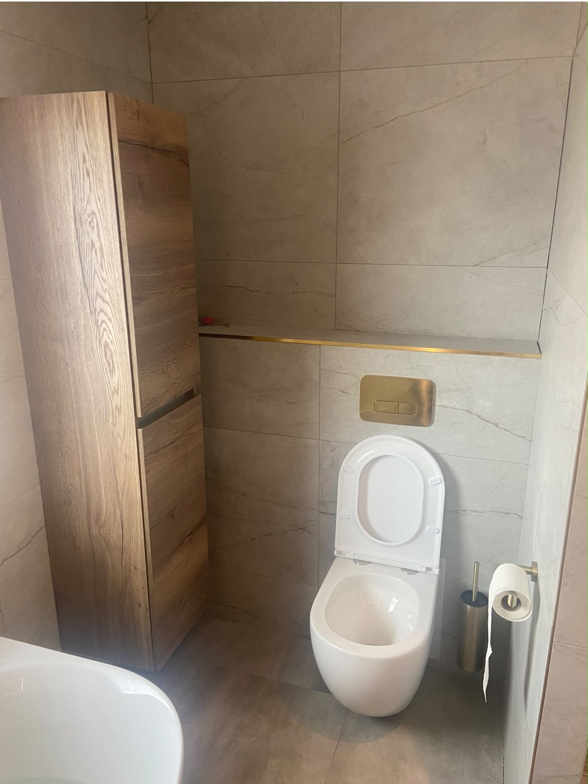Hangtoilet met gouden bedieningsplaat en maatwerkkast